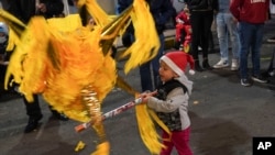 Seorang anak memukul piñata saat acara "posada" jalanan di Mexico City, Jumat, 22 Desember 2023. (AP Photo/Marco Ugarte)