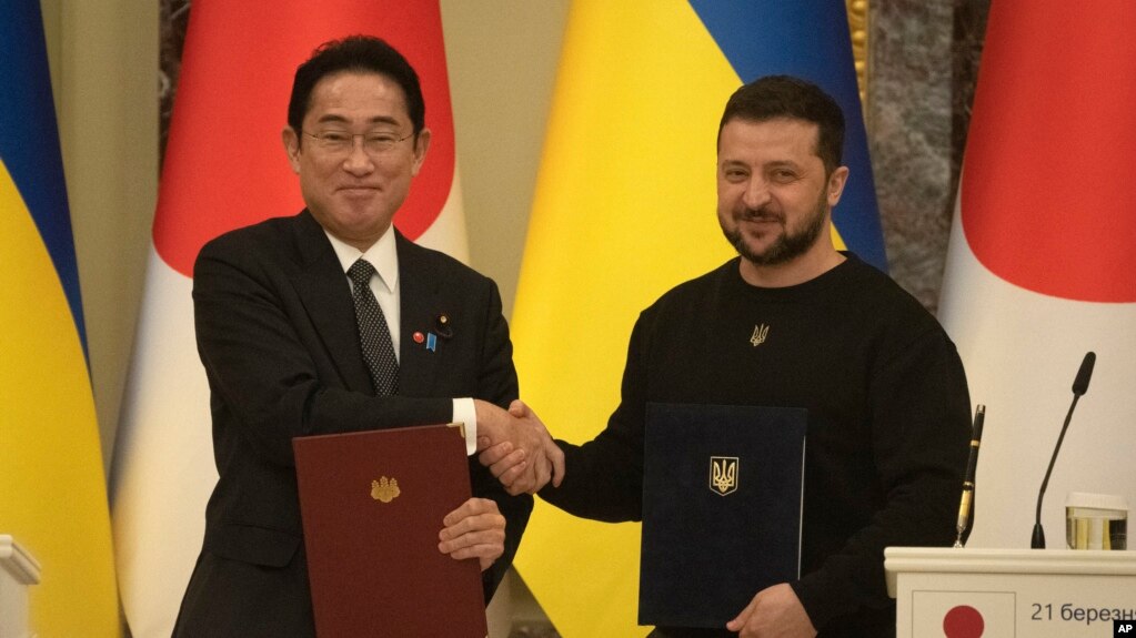 TƯ LIỆU - Thủ tướng Nhật Bản Fumio Kishida (trái) và Tổng thống Ukraine Volodymyr Zelenskyy bắt tay chào nhau sau lễ kí kết các văn kiện chung ở Kyiv, Ukraine, ngày 21 tháng 3 năm 2023.