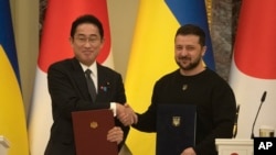 日本首相岸田文雄与乌克兰总统泽连斯基在基辅签署联合文件后握手。(2023年3月21日)