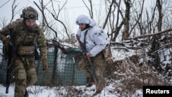 FILE - Bohdan, 'Fritz', the deputy of commander of the unit in 79th Air Assault Brigade, takes cover after firing towards Russian positions on a frontline near the town of Marinka, Feb. 14, 2023.