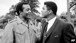 Petinju kelas berat Muhammad Ali, kanan, mengunjungi pemain belakang Cleveland Browns dan aktor Jim Brown di lokasi syuting "The Dirty Dozen" di Morkyate, Bedfordshire, Inggris. (Foto: AP)