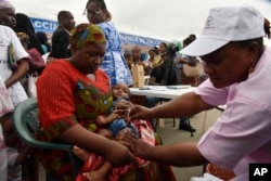 A health worker administers the malaria vaccine Oxford-Serum R21 to a child in Abidjan, Ivory Coast, Monday, July 15, 2024. (AP Photo/Diomande Ble Blonde)