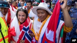 FILE - Norwegian climber Kristin Harila, left, and her Nepali sherpa guide Tenjen Sherpa, right, who climbed the world's 14 tallest mountains in record time, arrive in Kathmandu, Nepal, Aug. 5, 2023. A Pakistani mountaineer said on Aug. 12, 2023, that an investigation has been launched into the death of a Pakistani porter during Harila's record quest.