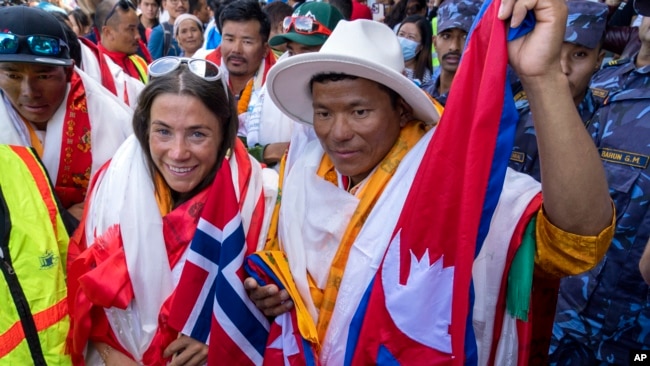 FILE - Norwegian climber Kristin Harila, left, and her Nepali sherpa guide Tenjen Sherpa, right, who climbed the world's 14 tallest mountains in record time, arrive in Kathmandu, Nepal, Aug. 5, 2023. A Pakistani mountaineer said on Aug. 12, 2023, that an investigation has been launched into the death of a Pakistani porter during Harila's record quest.