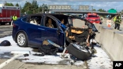 FILE - In this March 23, 2018, photo provided by KTVU, emergency personnel work at the scene where a Tesla electric SUV crashed into a barrier on U.S. Highway 101 in Mountain View, Calif. The crash killed an Apple engineer.