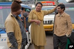 Preethi (tengah), mengobrol dengan sesama pengemudi becak saat menunggu pelanggan di Bengaluru, India, Rabu, 12 Juli 2023. (AP/Aijaz Rahi)