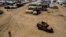 FILE - Kurdish forces patrol al-Hol camp, which houses families of members of the Islamic State group in Hasakeh province, Syria, on April 19, 2023. 