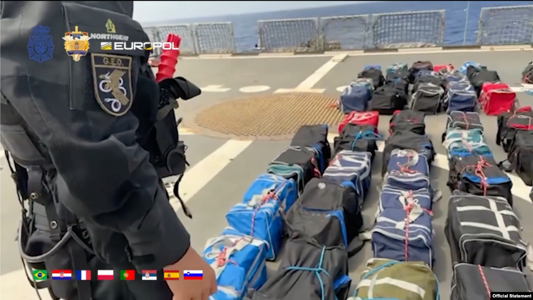 Fotografija napravljena od video snimka koji je objavio MUP Srbije 1. septembra 2023, na kojoj se vidi policajac kako stoji pored zaplenjenih putnih torbi sa kokainom, na Atlantiku.