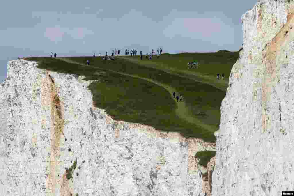 People walk on top of the cliff as they enjoy the weather at the Seven Sisters Cliffs, at Birling Gap in East Sussex county, Britain.