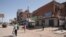 People walk past shuttered shops in Khartoum, Sudan, April 18, 2023.