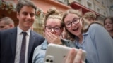 France&#39;s Prime Minister Gabriel Attal (left) poses for a selfie with young people during a campaign visit in Le Mans, northwestern France, ahead of the upcoming parliament elections.