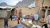 Warga Afghanistan mengumpulkan barang-barangnya di halaman rumahnya yang rusak akibat hujan lebat dan banjir bandang, di Kandahar, Minggu 14 April 2024.