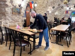 Ala'a Salameh, 42 zan, mete manje sou yon tab nan restoran li nan Bethlehem, 9 Desanm, 2023.