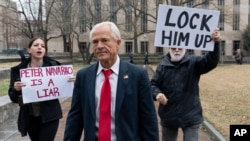 FILE - Former Trump White House official Peter Navarro, followed by demonstrators, leaves the U.S. Federal Courthouse in Washington, Jan. 25, 2024. 