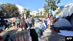 FILE: Sub-Saharan African migrants camp outside the headquarters of the International Organization for Migration in Tunis, Tunisia, on March 2, 2023