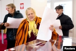 A woman votes during Polish parliamentary elections at a polling station in the village of Gluchow, Poland, October 15, 2023. (REUTERS/Lukasz Glowala)
