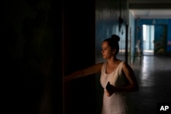 Katarina Chesta opens a door at her work in Kupiansk, Ukraine, Aug. 23, 2023. Chesta says she's staying because she is tired of packing up and running away from war.