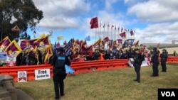 在澳大利亚国会大厦外的草坪上，藏人团体、港人团体和民运人士高举旗帜并呼喊口号抗议中国总理李强到访。（2024年6月17日）