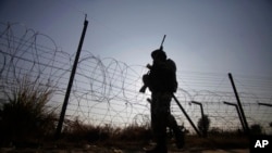 FILE - An Indian soldier patrols along the India-Pakistan international border in Kathua district, Dec. 6, 2013.
