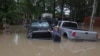 A man waves at Texas Parks & Wildlife Department game wardens as they arrive by boat to rescue residents from floodwaters, in Liberty County, Texas, May 4, 2024.