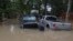 A man waves at Texas Parks & Wildlife Department game wardens as they arrive by boat to rescue residents from floodwaters, in Liberty County, Texas, May 4, 2024.