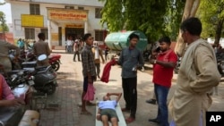 Mtu mzima akisumbuliwa na maradhi yanayotokana na joto kali akisubiri kulazwa hospitali ya wilaya ya district Ballia, Jimbo la Uttar Pradesh, India, Monday, June 19, 2023.