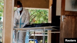 A worker wheels the remains of a follower of the Christian cult named Good News International Church, who was exhumed last year as the authorities begin to hand over bodies to family members, at the Malindi sub-district hospital mortuary on March 26, 2024.