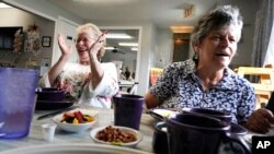 Debbie LaBarre, left, laughs while having breakfast as part of the Meals on Wheels "Dine Out Club" with her sister, Suzanne Marchand, right, at the White Birch Cafe in Goffstown, New Hampshire, Aug. 16, 2023.