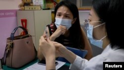 A nurse teaches Vivian Tung, 33, who is one of a rising number of women opting to freeze their eggs, how to use the hormone injections at the Shin Kong Wu Ho-Su Memorial Hospital in Taipei, Taiwan, June 12, 2023. (REUTERS/Ann Wang)