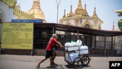 Người dân vận chuyển nước sinh hoạt ở Yangon, Myanmar, ngày 25/4/2024.