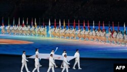 Para mantan atlet membawa bendera Dewan Olimpiade Asia saat upacara pembukaan Asian Games 2022 di Provinsi Zhejiang timur China pada 23 September 2023. (Foto; AFP)