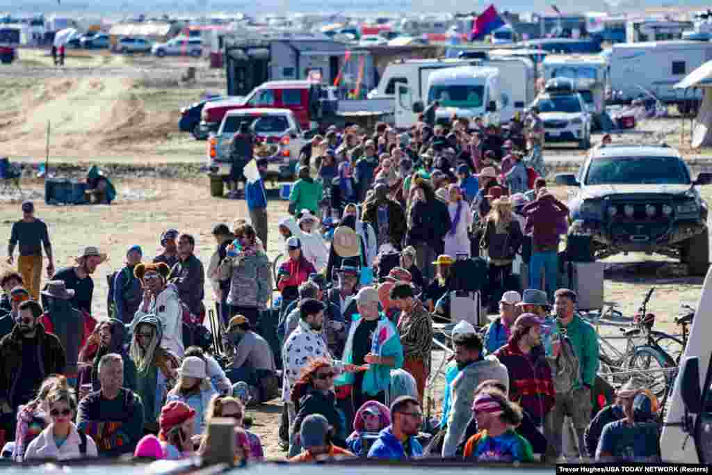 Hundreds of Burning Man attendees who planned to leave on buses wait for information about when they will be able to leave on Labor Day, after a rainstorm turned the site into mud, Sept. 4, 2023. 