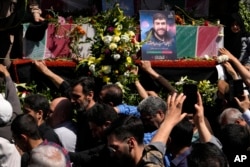 FILE—Mourners reach out to the flag-draped coffins of Revolutionary Guard members killed in an airstrike widely attributed to Israel that destroyed Iran's Consulate in Syria on Monday, in a funeral procession in Tehran, Iran, on April 5, 2024.