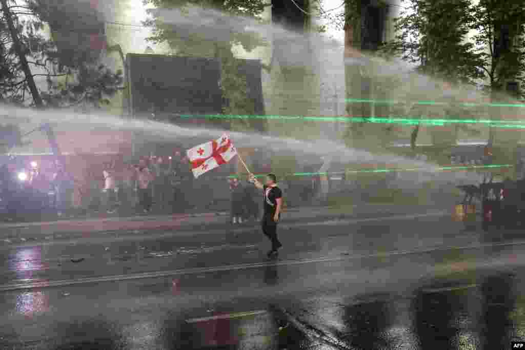 Police use water cannons to disperse protesters near the Georgian parliament during a rally against a controversial "foreign influence" bill, which Brussels warns would undermine Georgia's European aspirations, in Tbilisi, April 30, 2024. 
