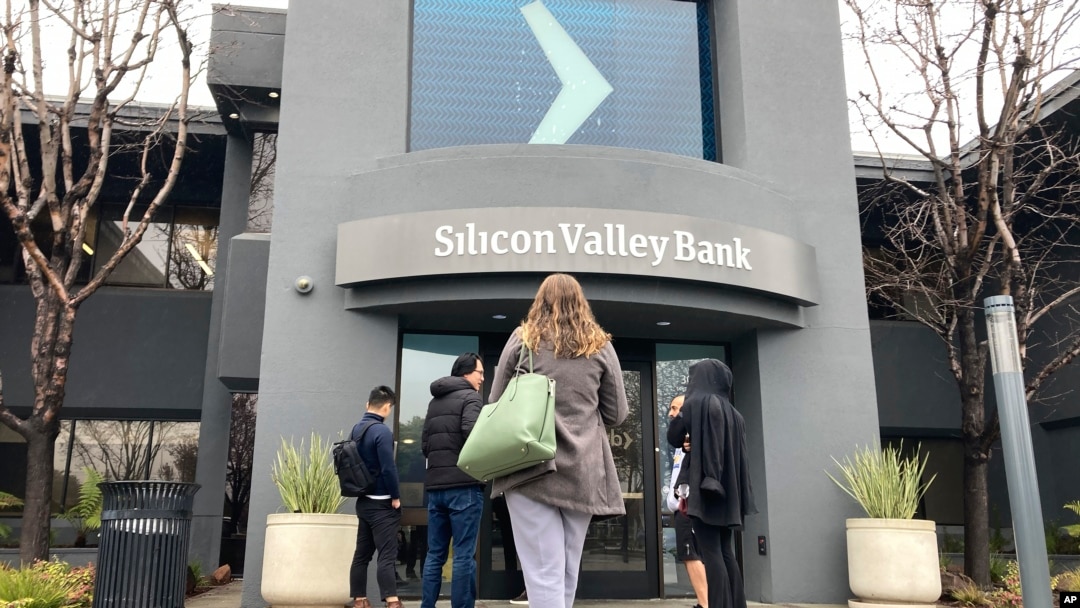 Sejumlah nasabah berdiri di luar pintu masuk Bank Silicon Valley di Santa Clara, California, Jumat, 10 Maret 2023. Lembaga Penjamin Simpanan Federal (FIDC) menyita aset-aset SVB yang menandai kebangkrutan bank terbesar sejak 2008 krisis finansial. (Foto: Jeff Chiu/AP Photo)
