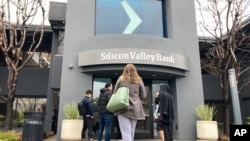 People stand outside of an entrance to Silicon Valley Bank in Santa Clara, California, March 10, 2023. 