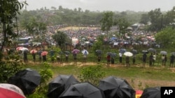 Hundreds of Rohingyas gather in the rain to demand safe return to Myanmar's Rakhine state as they mark the seventh anniversary of their exile from Myanmar at their refugee camp at Kutupalong in Cox's Bazar district, Bangladesh, Aug. 25, 2024.