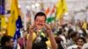 Seorang pendukung Partai Aam Admi memegang topeng yang mirip dengan pemimpin partai dan Ketua Menteri Delhi Arvind Kejriwal saat berdemonstrasi di New Delhi, India, Minggu, 31 Maret. 2024. (Foto: AP)