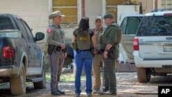 Law enforcement officials work in the neighborhood where a gunman, still at large, killed five people Friday night, in Cleveland, Texas, April 30, 2023.