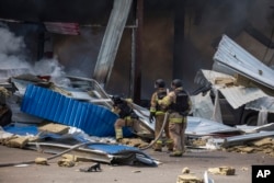 Firefighters extinguish flames after a Russian missile hit a supermarket in Kostiantynivka, Ukraine, Aug. 9, 2024.