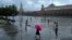 FILE - People with umbrellas walk under the rain through Red Square in Moscow, July 22, 2024. A U.S. citizen was detained on Aug. 12, 2024, in Moscow for allegedly attacking a police officer.