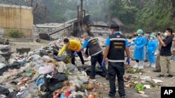 Petugas forensik polisi Thailand menyelidiki tempat pembuangan sampah saat mencari bagian tubuh seorang ahli bedah Kolombia di pulau Koh Phagnan, Thailand selatan, Jumat, 4 Agustus 2023. (AP/Somkeat Ruksaman)