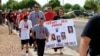 Deiandra Reid drži znak da skrene pažnju na svoju sestru Tiffany Reid, koja je nestala 20 godina ranije, dok desetine ljudi učestvuju u Danu svijesti o nestalim i ubijenim domorodačkim osobama u Albuquerqueu, Novi Meksiko, 5. maja 2024.