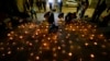 People light candles during a vigil for three police officer in front of Chile's police headquarters in Santiago, Chile, Saturday, April 27, 2024.