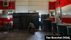 A man cooks on an improvised stove inside the former Velyka Novosilka, Ukraine firehouse, on Aug. 23, 2023 