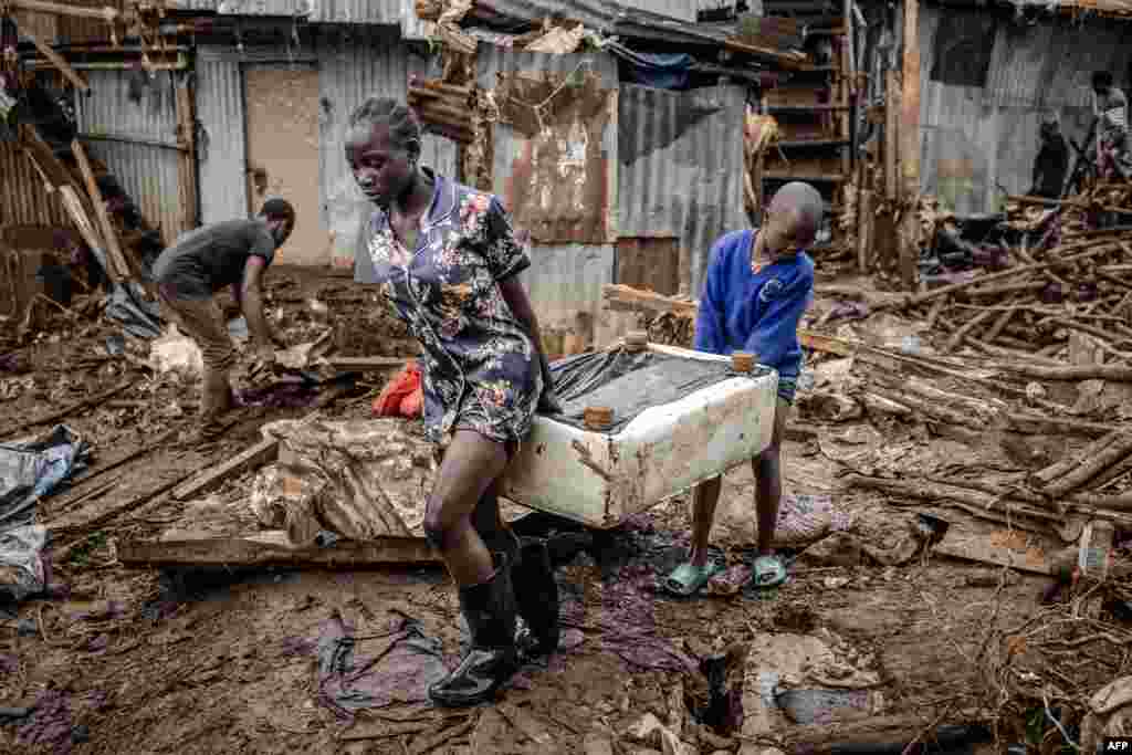 A girl and a boy carry a piece of furniture after visiting their house, which was destroyed by floods following torrential rains at the Mathare informal settlement in Nairobi.