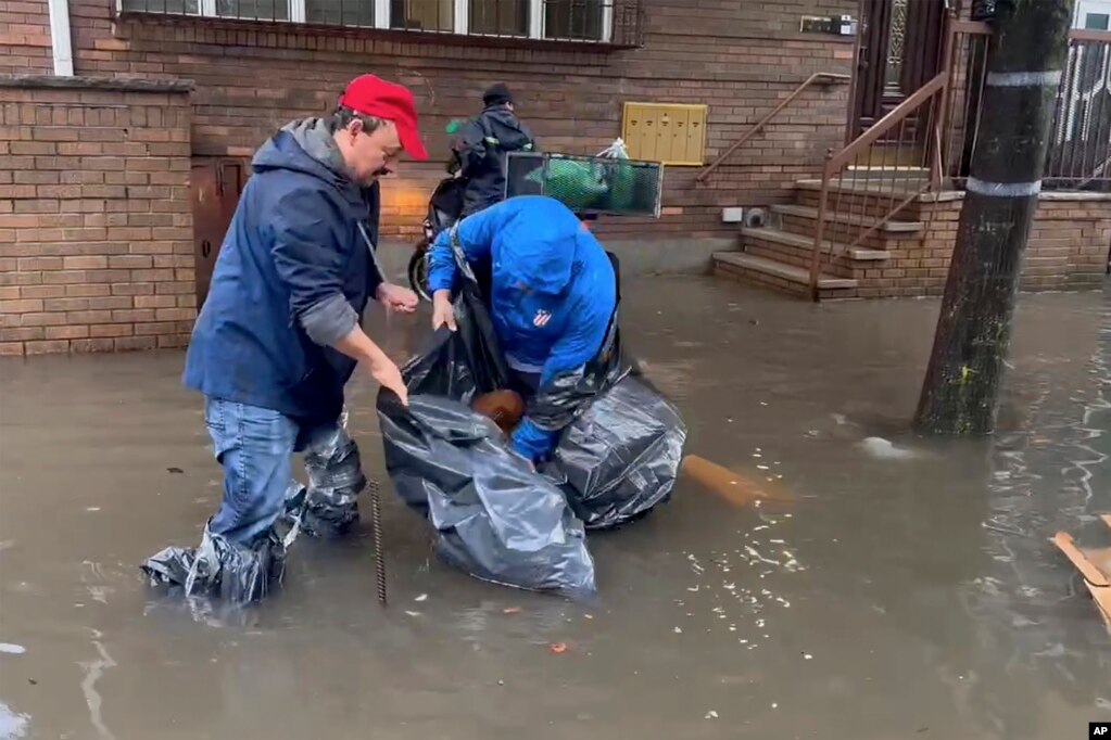 En esta foto tomada de un video, se trabaja en aguas inundadas para limpiar los desagües de una calle. 