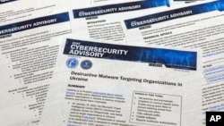 FILE - A Joint Cybersecurity Advisory published by the Cybersecurity & Infrastructure Security Agency about destructive malware that is targeting organizations in Ukraine is photographed, Feb. 28, 2022.