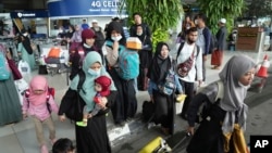 Indonesian citizens walk to a bus upon arrival after being evacuated from Sudan, at Soekarno-Hatta International Airport in Tangerang, Banten province, Indonesia, April 28, 2023.