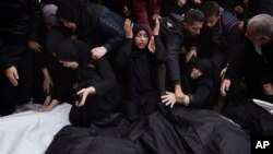 Palestinians mourn relatives killed in the Israeli bombardment of the Gaza Strip outside a morgue in Khan Younis, Dec. 20, 2023.